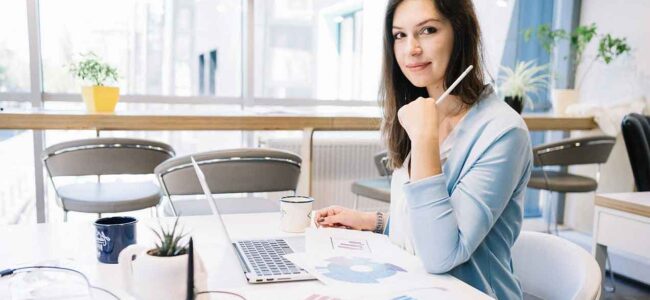 HR consultant sitting at a desk in a stylish modern office, providing professional employment law and HR advice for businesses in England and Wales